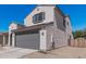 View of the property, featuring a two car garage door, a small yard, and desert landscaping at 2377 S 245Th Dr, Buckeye, AZ 85326