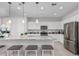 Modern white kitchen with stainless steel appliances, granite countertops, and bar stool seating at 2377 S 245Th Dr, Buckeye, AZ 85326