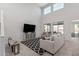 A large living room with high ceilings, large windows, and a neutral color scheme at 2377 S 245Th Dr, Buckeye, AZ 85326