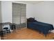 A minimalist bedroom with hardwood floors, single bed, and side table at 2650 W Union Hills Dr # 230, Phoenix, AZ 85027