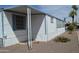 Cozy mobile home featuring white siding, blue trim, covered entryway, and desert landscaping at 2650 W Union Hills Dr # 230, Phoenix, AZ 85027