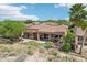 Aerial view showcases the home's covered patio, putting green, fire pit, desert landscaping, and neighboring residences at 27926 N 130Th Ave, Peoria, AZ 85383