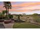 Inviting backyard with lush greenery, putting green, fire pit, and golf course views at 27926 N 130Th Ave, Peoria, AZ 85383