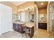 Primary bath featuring tile floors, dual sinks with custom cabinets, makeup vanity and neutral color scheme at 27926 N 130Th Ave, Peoria, AZ 85383