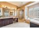 The luxurious primary bath has dual sinks, vanity seating, a soaking tub and walk-in shower at 27926 N 130Th Ave, Peoria, AZ 85383