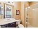 Neutral tiled bathroom with framed glass shower, single sink vanity and view into bedroom at 27926 N 130Th Ave, Peoria, AZ 85383