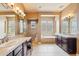 Large primary bath with tile floors, dual sinks, a vanity, soaking tub, walk-in shower and glass block windows at 27926 N 130Th Ave, Peoria, AZ 85383