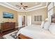 Spacious primary bedroom with a media center, dark wood floors and a tray ceiling with fan at 27926 N 130Th Ave, Peoria, AZ 85383