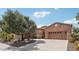 Charming home exterior with stone accents, mature landscaping, and circular driveway at 27926 N 130Th Ave, Peoria, AZ 85383