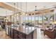 Spacious kitchen with island, sink, dark wood cabinets, and large windows overlooking the scenic backyard at 27926 N 130Th Ave, Peoria, AZ 85383