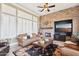 Warm living room featuring a stone accent wall, fireplace, and plantation shutters at 27926 N 130Th Ave, Peoria, AZ 85383