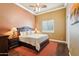 Inviting main bedroom with wood floors, a large bed, ceiling fan and bright natural light at 27926 N 130Th Ave, Peoria, AZ 85383