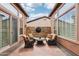 Enclosed patio features stone accent wall, tile floor and comfortable seating arrangement at 27926 N 130Th Ave, Peoria, AZ 85383