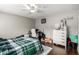 Bedroom featuring a desk, dresser, ceiling fan, and dark laminate flooring at 3109 W Loma Ln, Phoenix, AZ 85051
