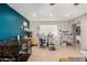 Bright open-concept living area featuring tiled floors, a modern desk area, and a blue accent wall at 3109 W Loma Ln, Phoenix, AZ 85051
