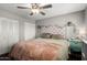 Well-lit bedroom with a tufted headboard, ceiling fan, and ample closet space at 3109 W Loma Ln, Phoenix, AZ 85051