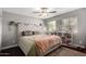 Bright bedroom with a ceiling fan, decorative vines, and a tufted headboard at 3109 W Loma Ln, Phoenix, AZ 85051