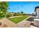 Large backyard featuring manicured artificial turf and mature landscaping, ideal for outdoor enjoyment at 3320 E Claire Dr, Phoenix, AZ 85032