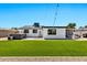 Home's backyard has a green lawn, hot tub, and patio perfect for relaxing and entertaining at 3320 E Claire Dr, Phoenix, AZ 85032