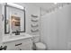 Bright bathroom featuring modern vanity, shower with curtain, and open shelving at 3320 E Claire Dr, Phoenix, AZ 85032