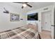 Well-lit bedroom with a ceiling fan, dresser, and television at 3320 E Claire Dr, Phoenix, AZ 85032