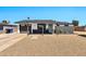 Charming single-story home featuring a black garage door, desert landscaping, and a welcoming covered entry at 3320 E Claire Dr, Phoenix, AZ 85032
