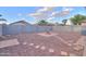 Spacious backyard featuring a charming fire pit, walkway, desert landscaping, and a concrete block perimeter fence at 40054 W Tamara Ln, Maricopa, AZ 85138