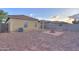 Spacious backyard featuring a charming fire pit, desert landscaping, and a concrete block perimeter fence at 40054 W Tamara Ln, Maricopa, AZ 85138