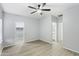 Large bedroom with fan, access to walk-in closet and bathroom, and elegant wood-style flooring at 40054 W Tamara Ln, Maricopa, AZ 85138