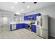 Bright, updated kitchen featuring stainless steel appliances, blue cabinets and a seamless connection to the living area at 40054 W Tamara Ln, Maricopa, AZ 85138