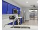 Modern kitchen featuring stainless steel appliances, bright blue cabinets, and a convenient sliding glass door at 40054 W Tamara Ln, Maricopa, AZ 85138
