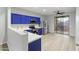 Stylish kitchen with stainless steel appliances, vibrant blue cabinetry, and access to the outdoor space at 40054 W Tamara Ln, Maricopa, AZ 85138