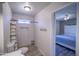 Bathroom leading to a bedroom with a ceiling fan and window, all contributing to a functional design at 402 W Mohawk Ln, Phoenix, AZ 85027