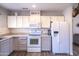 Bright kitchen featuring white appliances, light gray cabinets, and ample counter space at 402 W Mohawk Ln, Phoenix, AZ 85027