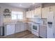 Bright kitchen featuring a modern stainless sink, white appliances, and soft gray cabinetry at 402 W Mohawk Ln, Phoenix, AZ 85027