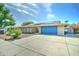 Attractive brick home featuring a well-manicured desert yard and a bright blue garage door at 4023 W Joan De Arc Ave, Phoenix, AZ 85029