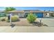Charming brick home featuring a well-maintained yard, solar panels and a bright blue garage door at 4023 W Joan De Arc Ave, Phoenix, AZ 85029
