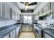 Cozy kitchen featuring stainless steel appliances, gray cabinets, dark countertops, and a bright window at 4023 W Joan De Arc Ave, Phoenix, AZ 85029