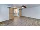 Bright bedroom featuring wood-look flooring, modern ceiling fan, and sliding barn doors at 4023 W Joan De Arc Ave, Phoenix, AZ 85029