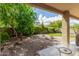 Relaxing backyard featuring a covered patio, gravel, mature landscaping, and lush green trees at 4125 W Lydia Ln, Phoenix, AZ 85041