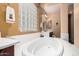 Bright and spacious bathroom featuring a luxurious soaking tub, glass block window, and dark wood cabinets at 4125 W Lydia Ln, Phoenix, AZ 85041