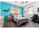 Bright bedroom with blue accent wall, wood blinds and neutral carpeting at 4125 W Lydia Ln, Phoenix, AZ 85041