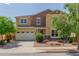 Inviting two-story home featuring a three-car garage, landscaped yard, and a mix of textures and colors on the facade at 4125 W Lydia Ln, Phoenix, AZ 85041