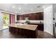 This kitchen features dark wood cabinets, a granite island, stainless steel appliances, and a view to the backyard at 4125 W Lydia Ln, Phoenix, AZ 85041
