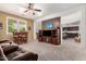 Cozy living room featuring neutral carpet, ceiling fan and natural light with view into the kitchen at 4125 W Lydia Ln, Phoenix, AZ 85041