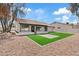 Charming home featuring a manicured backyard with a gravel perimeter and synthetic grass lawn at 438 E Hackamore St, Mesa, AZ 85203