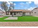 Charming single-story home featuring a manicured backyard with a gravel perimeter and synthetic grass lawn at 438 E Hackamore St, Mesa, AZ 85203