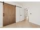 Bright bedroom with wood floors, sliding barn door, and entry door at 438 E Hackamore St, Mesa, AZ 85203