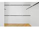 Empty walk-in closet with wood floors, white walls, and shelving and rods for storage at 438 E Hackamore St, Mesa, AZ 85203