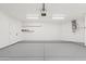 Bright garage with epoxy floor, ample space, shelving, and water heater at 438 E Hackamore St, Mesa, AZ 85203